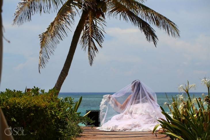 Chica sentada a la orilla de una playa con un portaretratos a un lado 