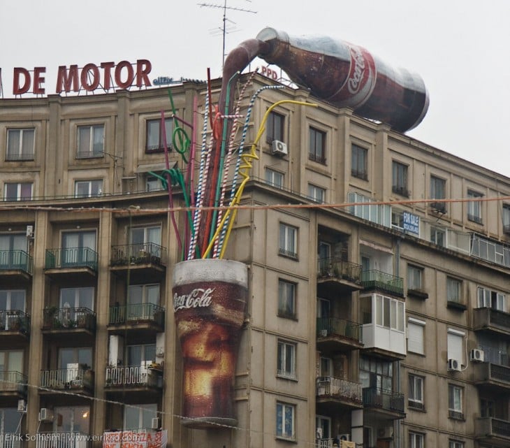 botella de coca cola derramandose sobre un edificio