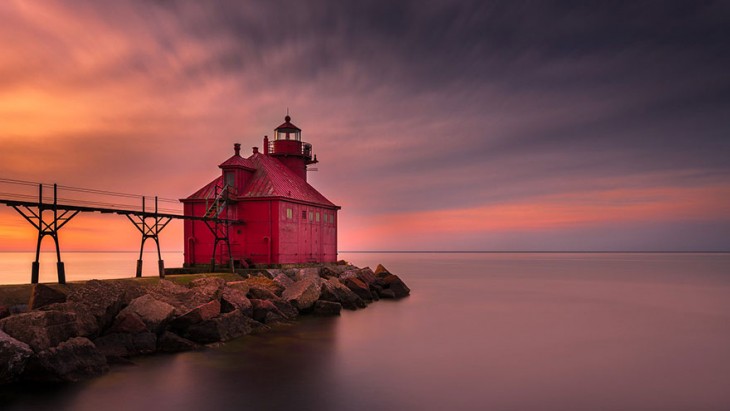 faro con forma de casita en atardecer