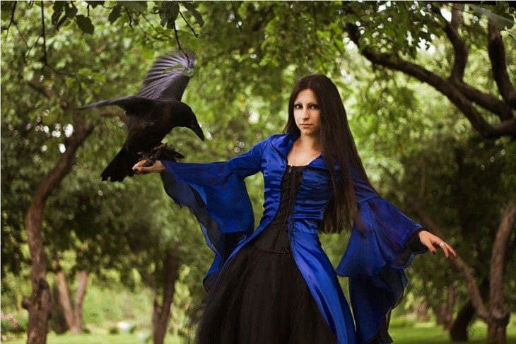 mujer vestido azul con cuervo
