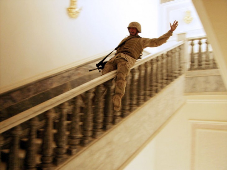 soldado resbalandose por el pasamanos de una escalera