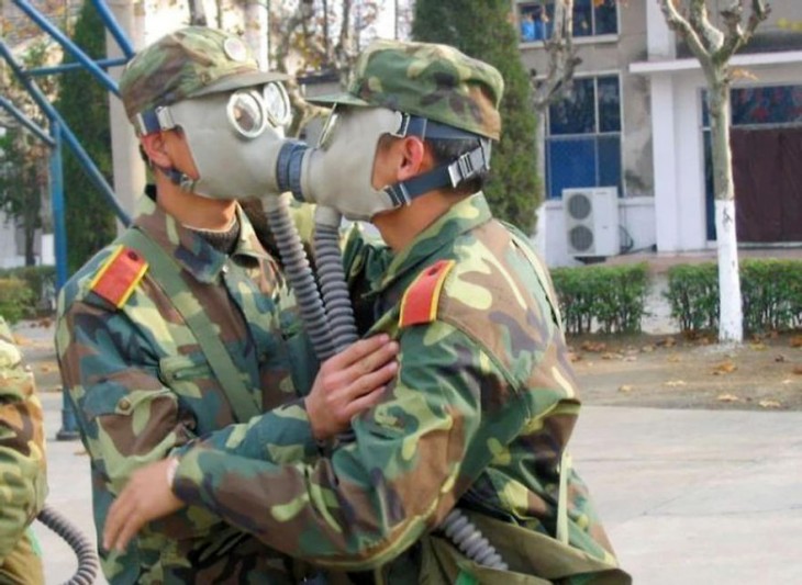 soldados dandose un beso con mascarillas puestas