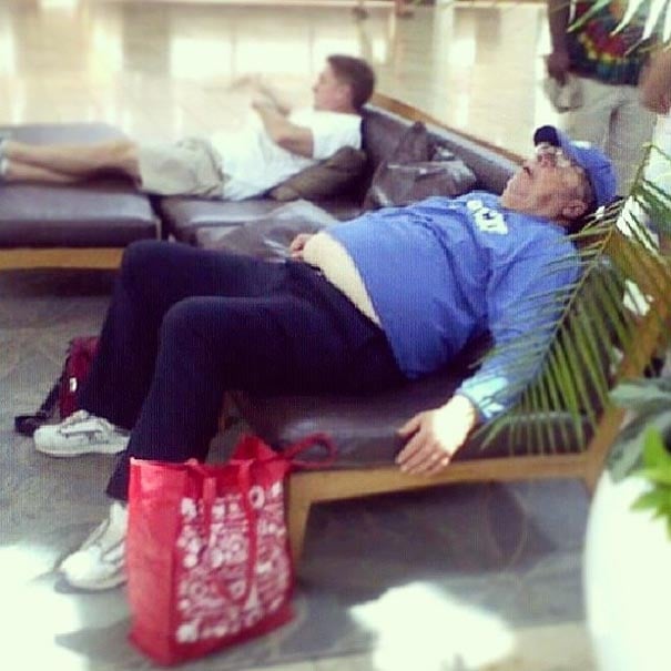 señor dormido en una banca con una bolsa de compras