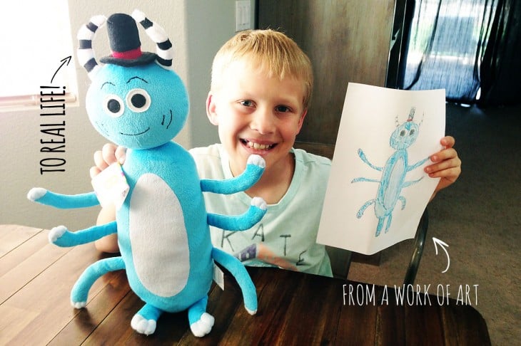 Niño sonrriendo con un dibujo y un peluche