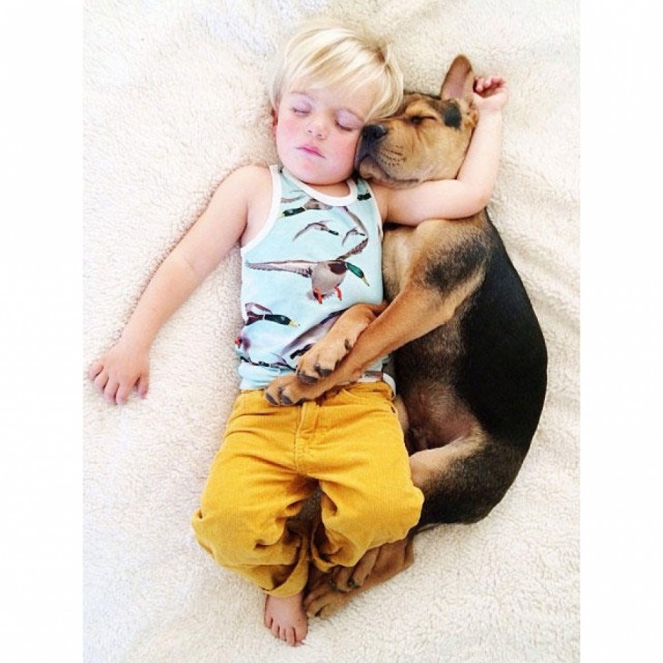 niño con pantalon amarillo dormido con el perro