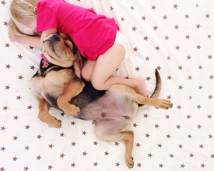 sabana con puntos rojos y niño dormido con perro pastor aleman