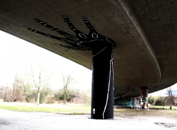 una mano pintada en el soporte de un puente