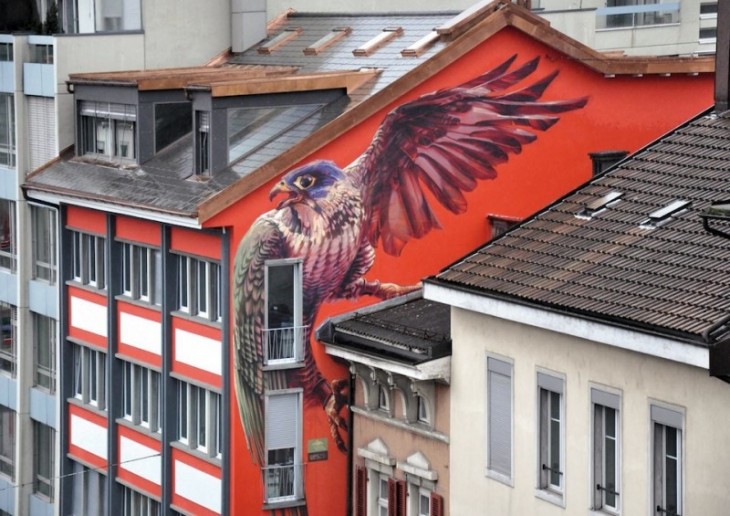 pajaro con alas abiertas plasmado en la pared de una casa naranja