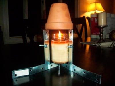 calentador hecho con una base metalica y tres jarrones de barro