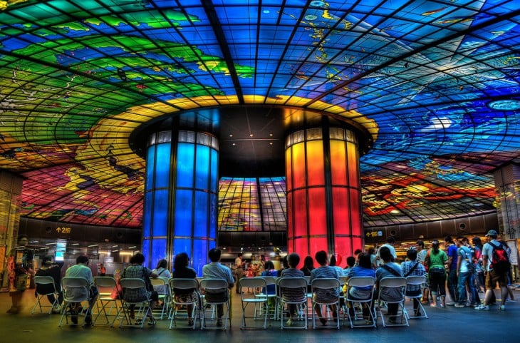 colorida estacion del metro que presenta luces en el techo y en dos pilares