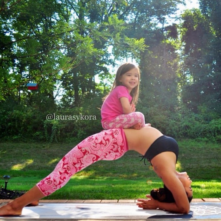 niña arriba de su madre en una postura de yoga