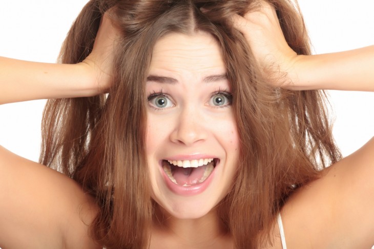 mujer gritando estirandose el cabello con las manos