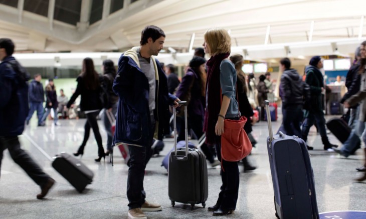 Pareja de novios en un aeropuerto repleto de gente 