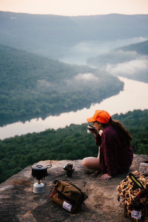 Mujer tomando café en una montaña 