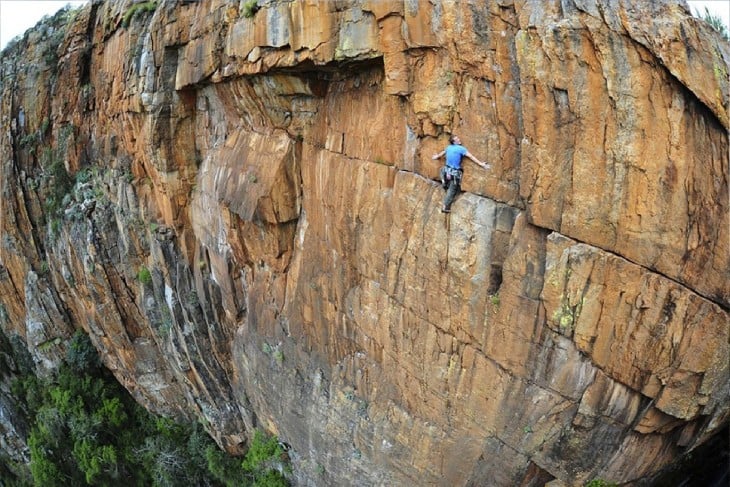 hombre escalando riscos