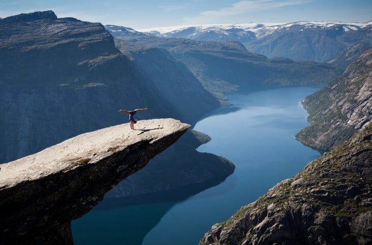 hombre arriba de una roca viendo lago