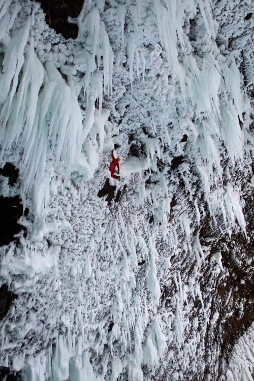 hombre escalando risco con hielo