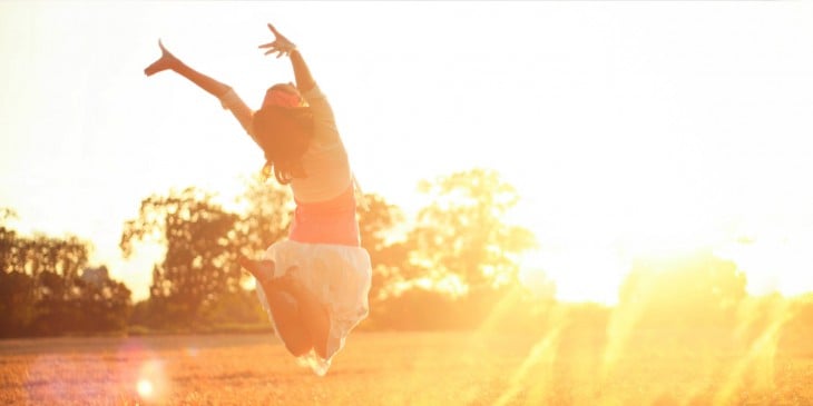 Mujer saltando de Felicidad en una puesta de Sol