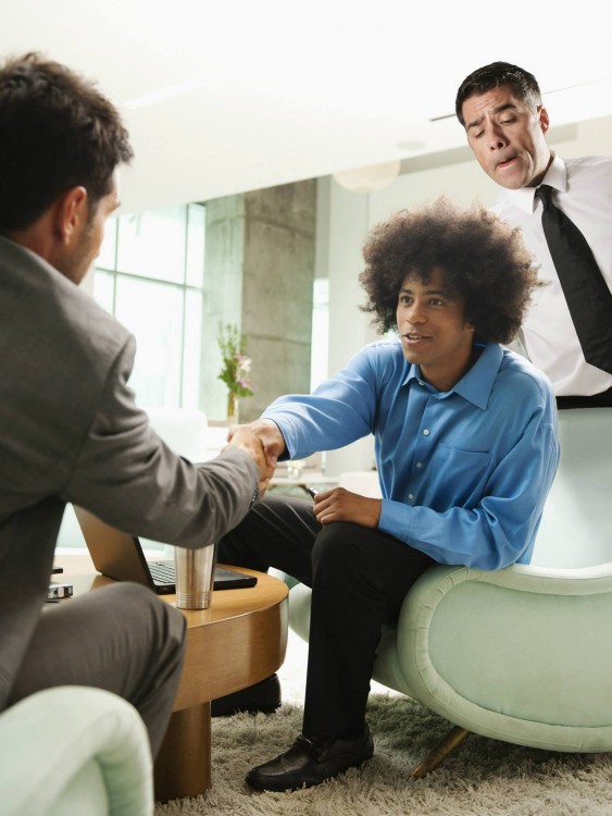 dos hombres sentados hablando y otro interrumpiendo