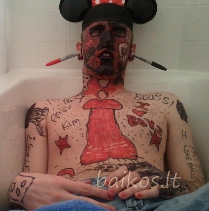 dormido en una tina, con orejas de Mickey, y un pene pintado en la barriga