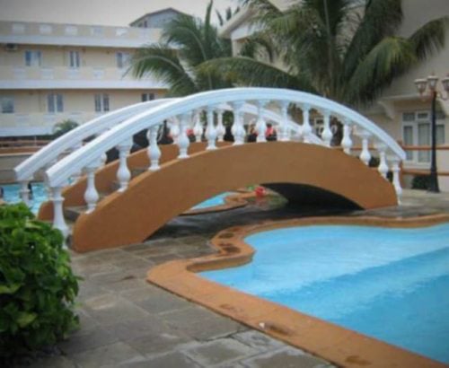 puente que pasa sobre el pasillo junto a una piscina 