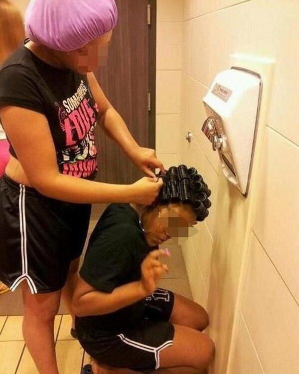 chicas se trenzan el pelo en un baño público