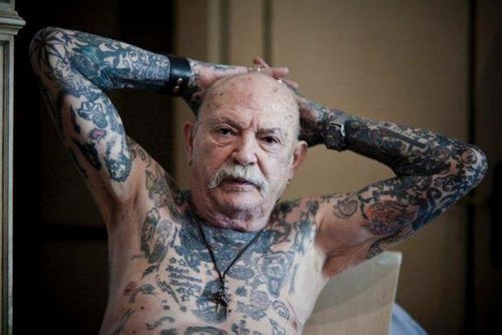 Anciando mostrando sus tatuajes del pecho y brazos 