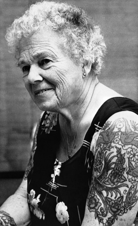 Mujer de edad adulta luciendo tatuajes en los brazos 