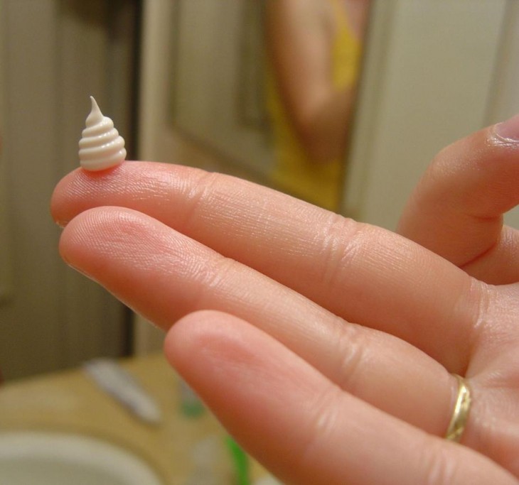 rollito de crema en los dedos de una persona 