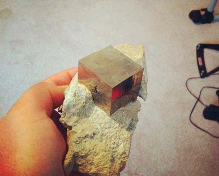 cubito de metal incrustado en piedra 