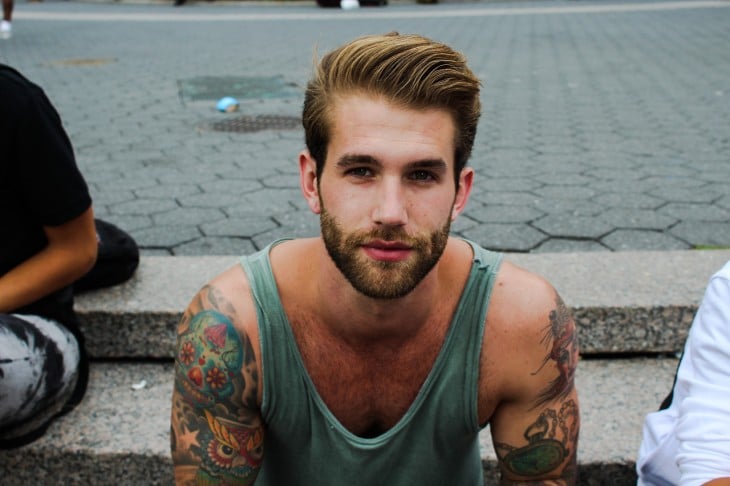 Hombre con barba y tatuajes en el cuerpo 