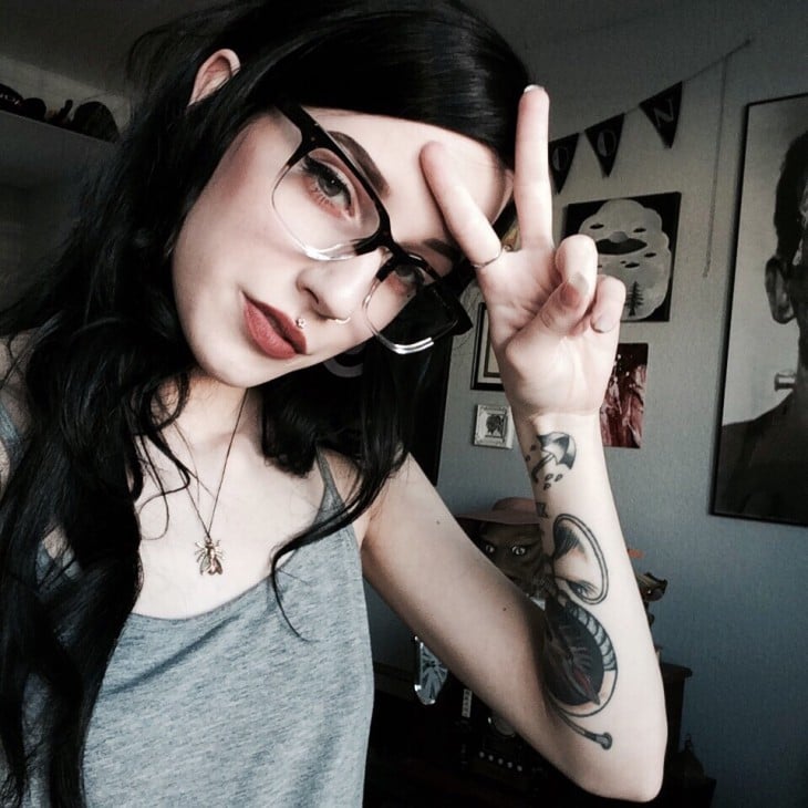 Chica de cabello negro y lentes con tatuaje