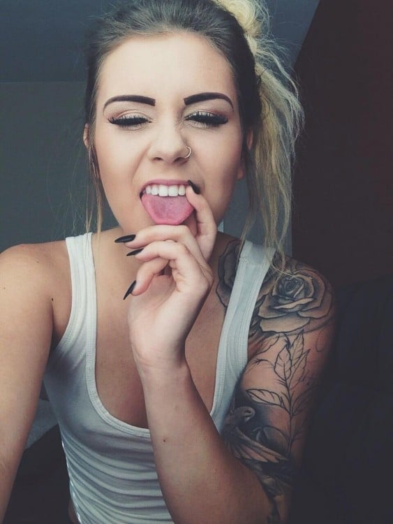 chica tatuada sacando la lengua 