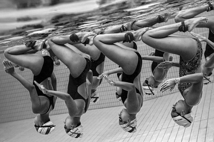 Mujeres de nado sincronizado de cabeza bajo el agua
