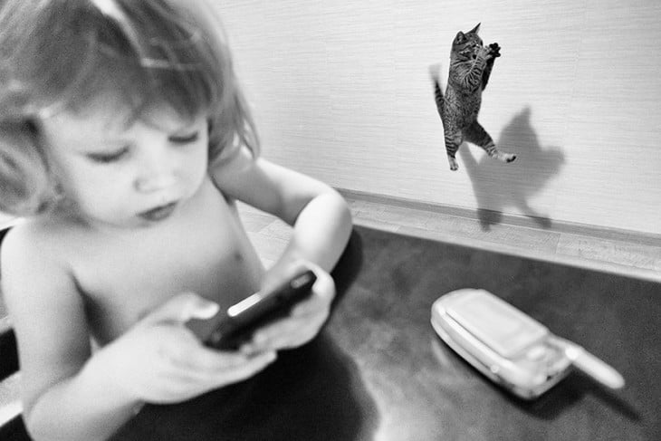 niña con un celular y de fondo un gato saltando 