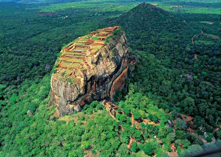 Imagen que muestra un paisaje con áreas verdes y una enorme montaña al centro 