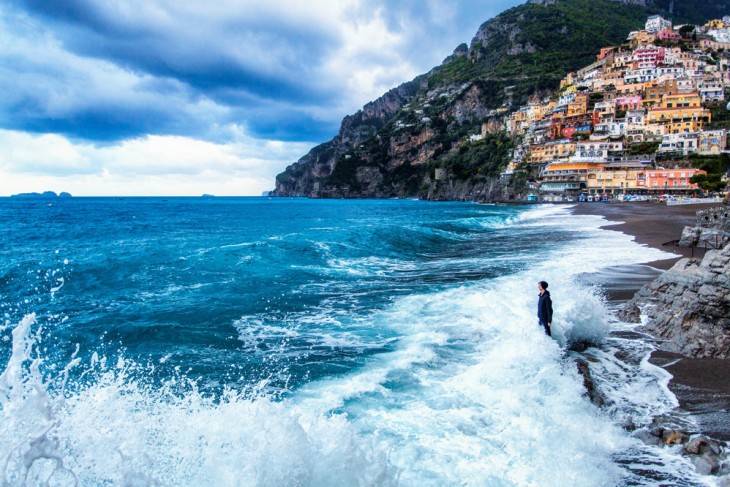 Un chico es golpeado por las olas a la orilla de una costa en Italia 