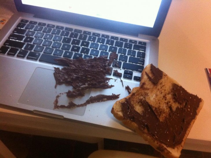 Laptop llena de nutella con un pedazo de pan 