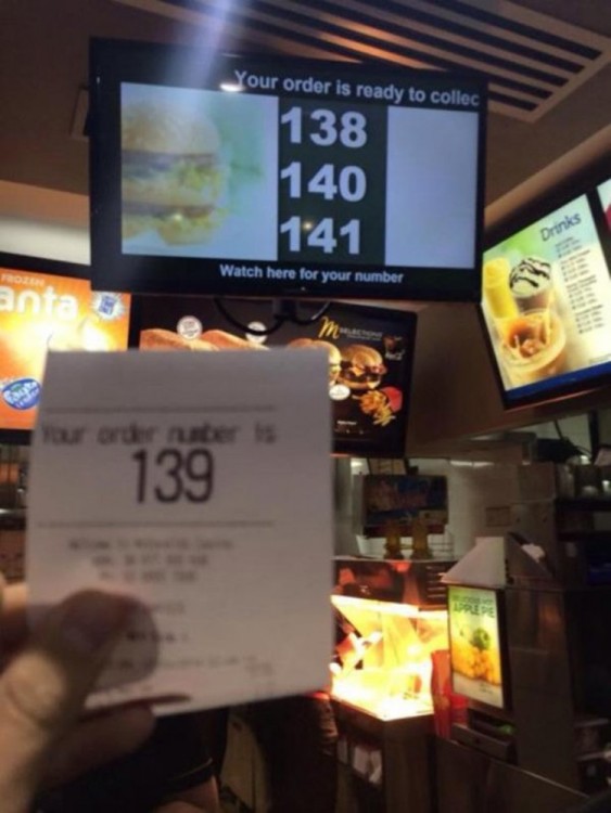Mano mostrando el número de turno en un local de comida rápida 
