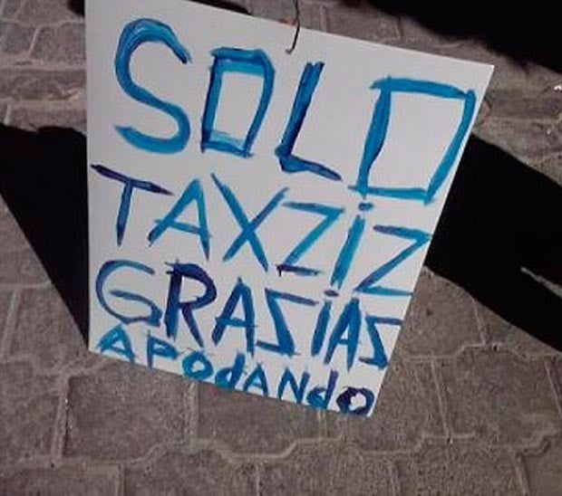 Letrero blanco con tinta azul donde dice algo acerca de los taxis 