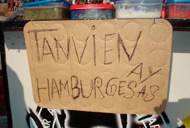 Letrero sobre un cartón con mala ortografía diciendo que si hay hamburguesas 