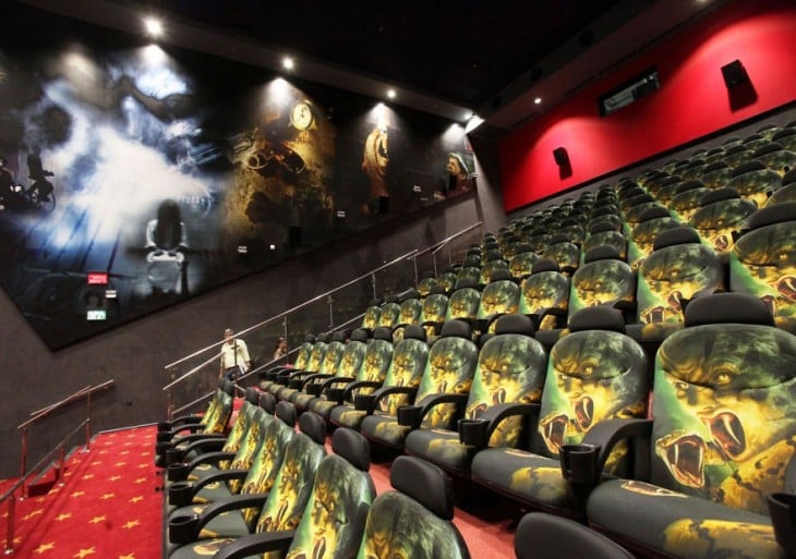 Sala de un cine con un estilo moderno y en sus asientos diseños de cobras y personajes de películas de acción 