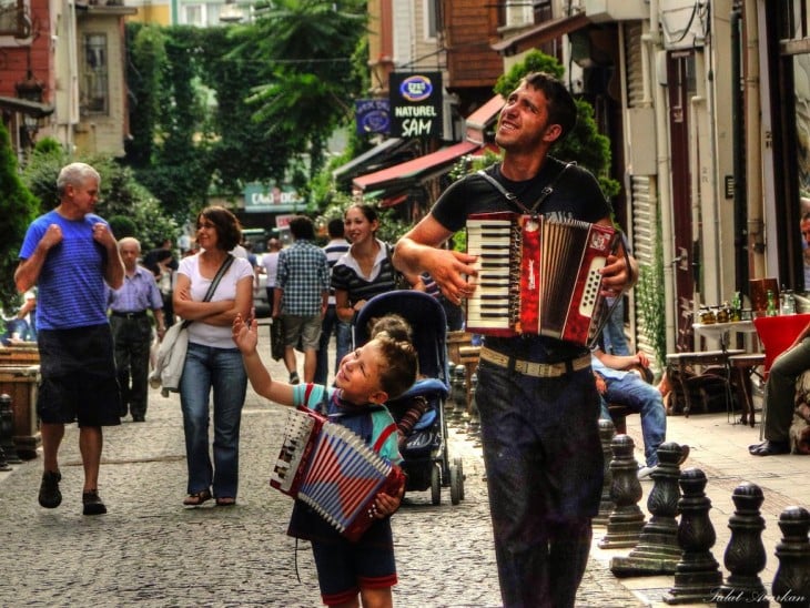 Un padre a un lado de su hijo con un acordeón cada uno 