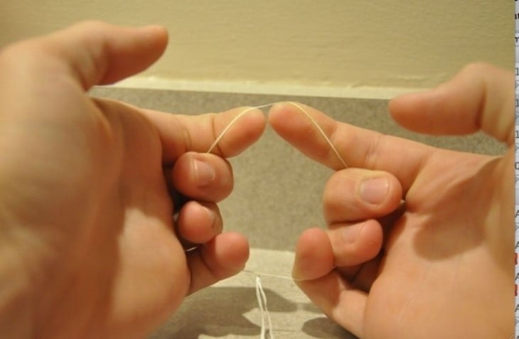 Hilo dental hecho circulo entre los dedos 