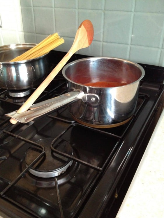 olla con salsa roja y cuchara en la estufa 