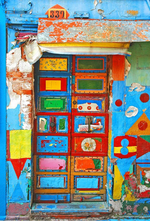 puerta de una casa con diferentes colores donde predomina el color azul, verde y amarillo 