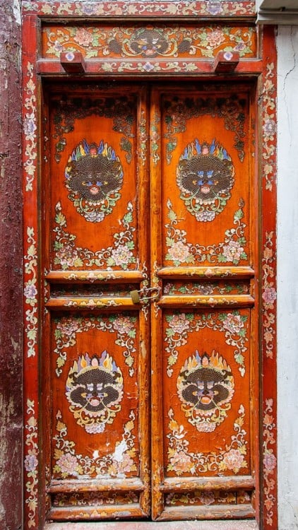 Puerta en China con cuatro separaciones y en con diseños de caras de dragones en cada una de sus cuatro separaciones 