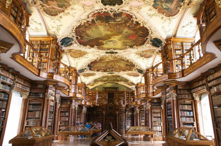 Biblioteca con un estilo clásico y en el techo diseños con formas de flores y dibujos de estilo romano en su interior