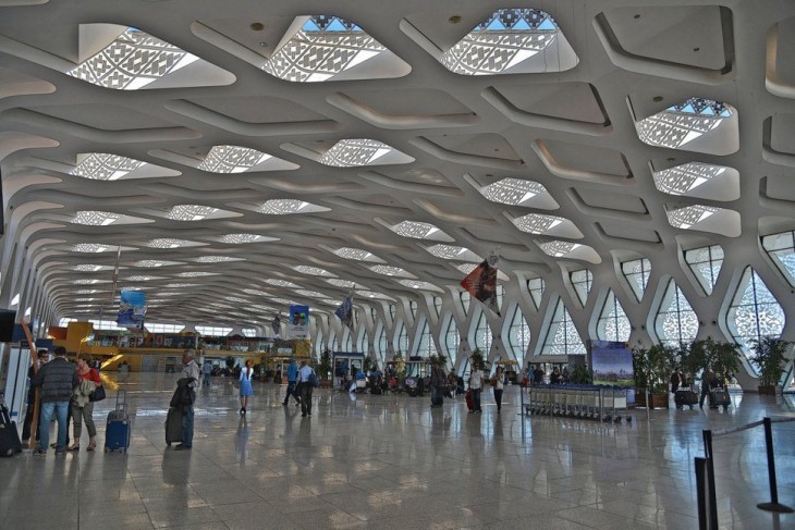 Estancia principal de un aeropuerto con pequeñas ventanas con vidrios en formas de cuadros 