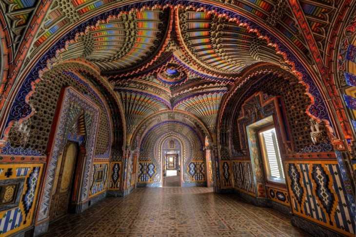 Sala con arcos y techos con formas de semi circulos en diferentes colores donde predominan los colores pasteles como el verde, rosa y azul 